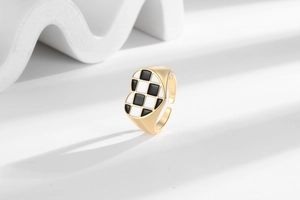 Artistic detail of a heart-shaped checkerboard ring on a white minimalist background