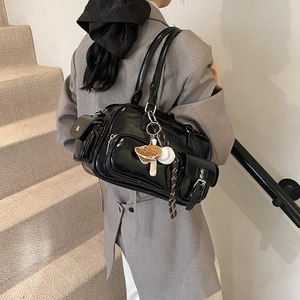 Retro black glossy tote bag with baseball charms on a model in a casual indoor setting