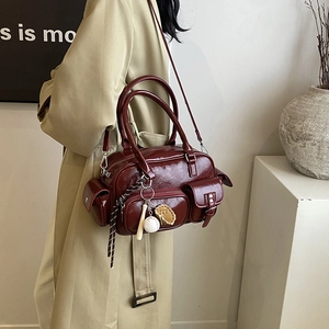 Vintage burgundy leather tote bag with multi-pocket design and stylish baseball charm