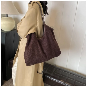 Detail of teddy fleece tote bag texture with leather straps on model in trench coat