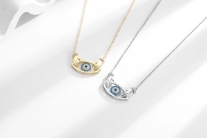 Macro detail of gold and silver evil eye pendants with blue crystals and mini hands