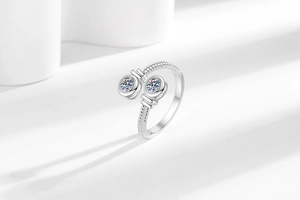 Close-up of a silver bypass ring featuring twin cz stones and a beaded texture band