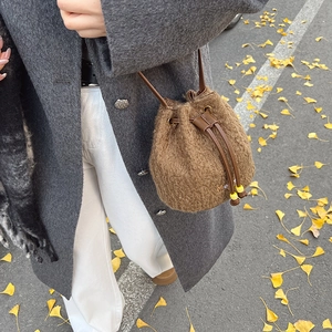 Winter plush drawstring bucket bag in brown faux fur with sleek shoulder strap