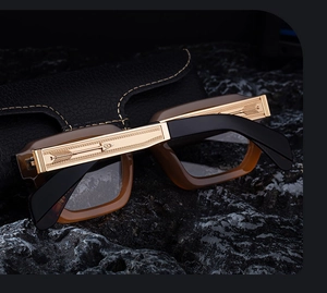 Detail of premium square glasses frame with golden metal arrow engraving and brown acetate