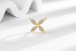 Macro detail of gold clover ring with micro-pave zircons and minimalist open band design