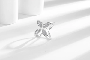 Macro detail of silver four-leaf clover ring with micro-pave crystals and open band