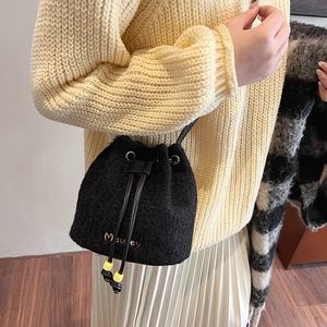Stylish black plush bucket bag with drawstring closure and striped beads for winter