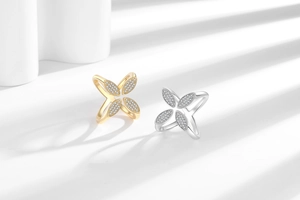 Macro view of crossover rings featuring pave-set zircon clover designs in gold and silver