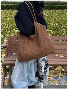 Detailopname van bruine teddy-tote bag met lederen bandjes op een bank in het park