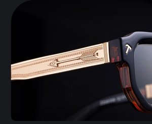 Detailed macro shot of vintage gold metal temples with arrow relief and T logo