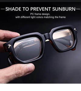 Detail of square black PC frame sunglasses with gold T-decoration and tinted lens