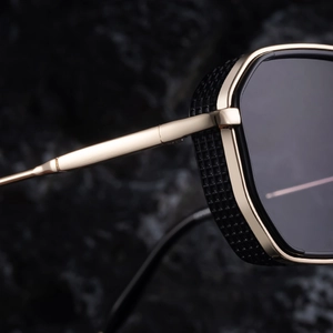Detail of retro steampunk sunglasses with gold metal temples and black mesh side shields