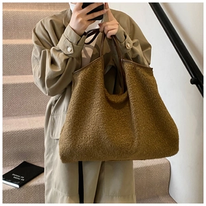 Detail of plush brown shearling tote bag with premium leather handles for women