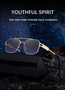 Detail of gold metal square sunglasses with grey gradient lenses on a dark rocky background