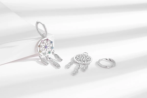 Macro detail of silver dreamcatcher earrings with multi-colored gems and feather charms