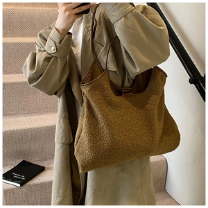 Chique sherpa tote tas met kunstleren bies gestyled op een trenchcoat voor herfstmode