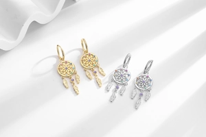 Detail view of dreamcatcher earrings with colorful zircons and metallic feathers