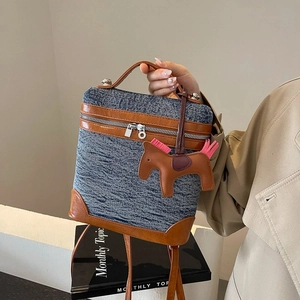Piccola borsa retrò in denim con finiture in pelle marrone e ciondolo a cavallo