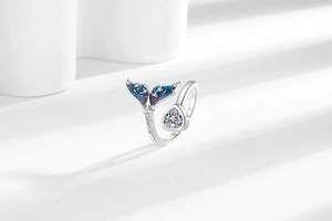 Detailed view of silver mermaid tail ring with blue enamel and heart-shaped zircon stone