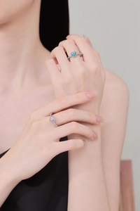 Detailansicht der Silberringe mit herzförmigen blauen und rosa Zirkoniasteinen und Pavé-Besatz