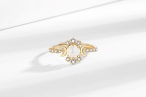 Makroaufnahme Goldring mit Opal und Mondsicheln sowie glitzernden Zirkonia-Steinen