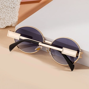 Detail of vintage oval sunglasses with gold textured metal frames and gradient lenses