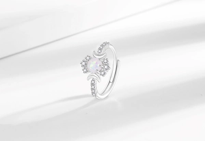 Makroaufnahme: Ring mit weißem Opal, Mondsicheln und funkelnden Zirkonia-Steinen
