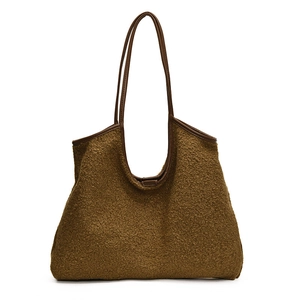 Detail van bruine pluche tote bag met leren hengsels en zachte lamswol textuur