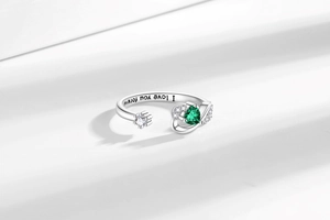 Detail of adjustable heart ring showing green teardrop gem and I love you forever engraving