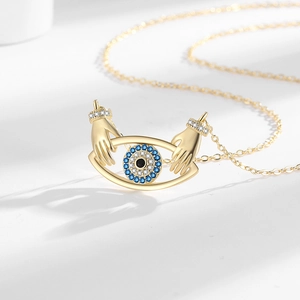 Golden necklace featuring a unique hands-hugging evil eye pendant with tiny cubic zirconia