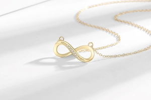 Detailaufnahme der Unendlichkeitskette mit Kristallbesatz und goldenem Finish