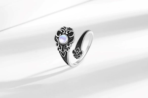Detailed shot of a vintage adjustable ring with heart patterns and moonstone inlay