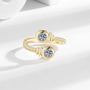 Adjustable gold twisted ring with sparkling dual round zirconia accents on a white background