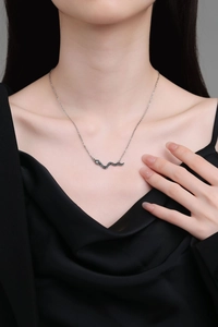 Collana con ciondolo a serpente d'argento con scaglie nere indossata sul collo