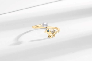 Détail macro de la bague éléphant avec perle blanche et œil de saphir bleu doré