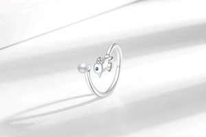 Détail de la bague réglable en argent avec perle blanche et motif d'oiseau serti de pierres