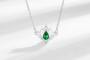 Detailed view of hollow lotus pendant with pear-shaped green gemstone in 925 silver