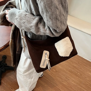 Women's dark brown crossbody tote with cream fuzzy pocket and adjustable strap