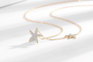 Détail du collier étoile de mer doré avec zircons blancs sertis sur une chaîne à mailles