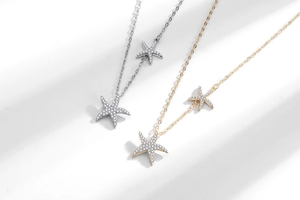 Détail de pendentifs étoile de mer en or et argent avec pavé de zircons étincelants