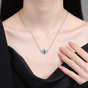 Elegant hollow lotus pendant necklace with pear-cut green gemstone on a silver chain