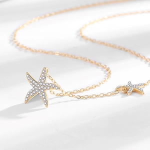 Collier doré avec deux pendentifs étoile de mer pavés de zircons brillants et fins