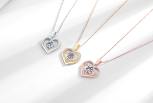 Dettaglio di ciondoli a cuore in argento, oro e oro rosa con pietre danzanti