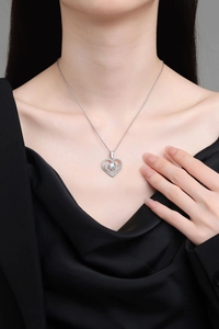 Dettaglio della collana a cuore con pietra portafortuna e diamante brillante al collo