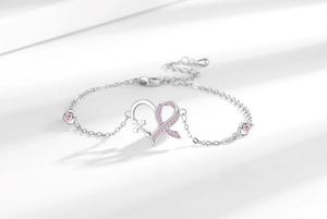Detailed shot of silver heart bracelet with pink ribbon cross and heart zircon accents
