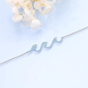 Sparkling wave pendant necklace with light blue stones on a fine silver-toned chain