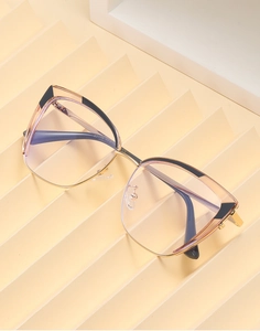 Detail of rose gold cat-eye glasses frame with pink and black acetate inserts