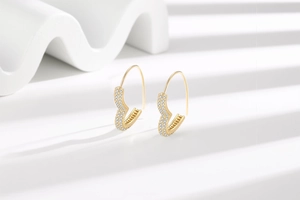 Detailed view of gold heart-shaped earrings with shimmering pave-set cubic zirconia stones