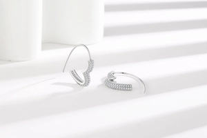 Macro detail of silver heart-shaped earrings with shimmering micro-pave crystal inlay