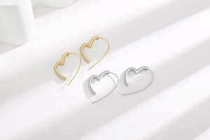 Detailed view of silver and gold heart earrings with sparkling pavé cubic zirconia
